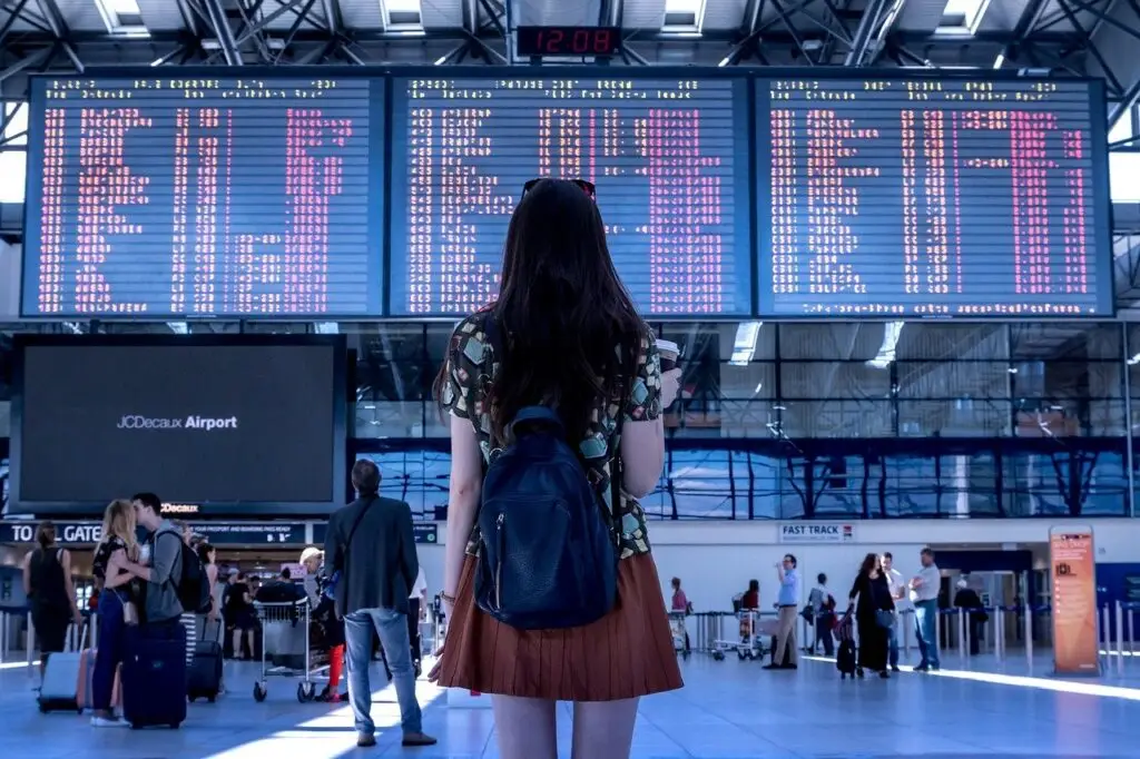 woman looking at flight status board